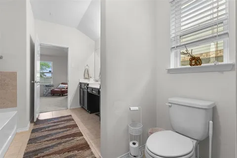 a bathroom with a toilet and a view of a bathroom