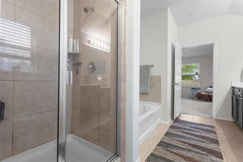 a bathroom with a glass shower door and a bathtub