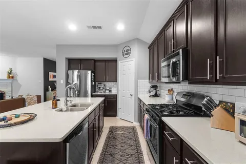a kitchen with stainless steel appliances granite countertop a sink a stove and refrigerator