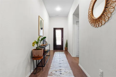 a hallway with painting on the wall and a potted plant