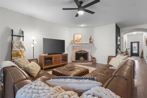 a living room with furniture a flat screen tv and a fireplace