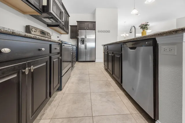 a kitchen with stainless steel appliances granite countertop a refrigerator and a sink
