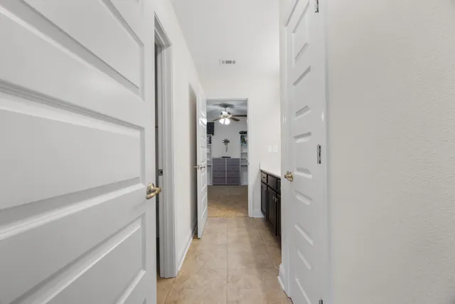 a spacious bathroom with a double vanity sink a mirror a lamp and a bathtub