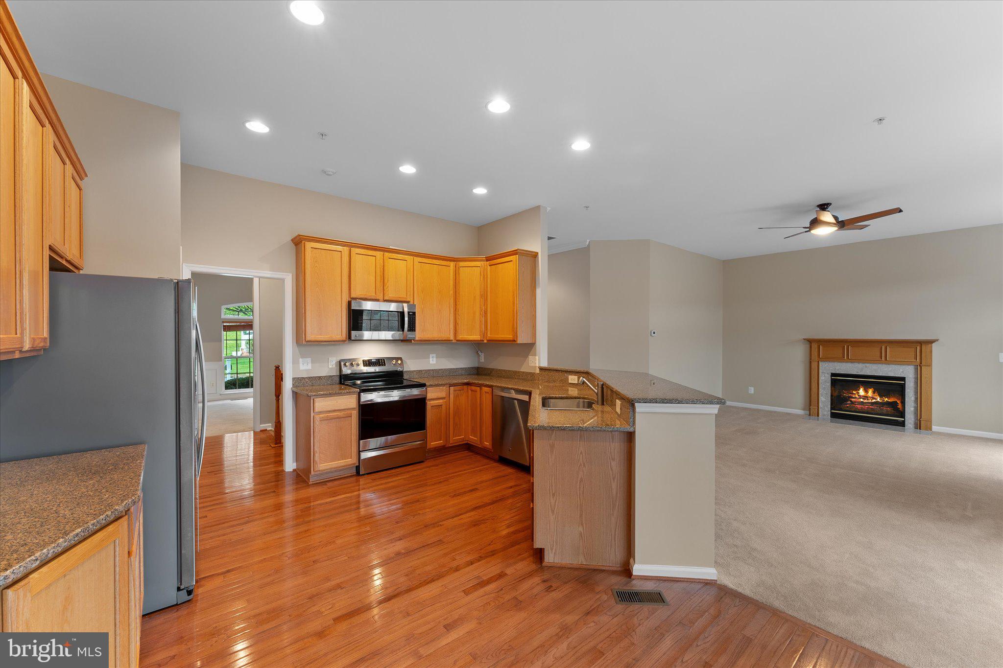 6696 Stream View Lane Warrenton, VA 20187 - Photo 10 of 57 a kitchen with stainless steel appliances granite countertop a refrigerator a stove and a wooden floors