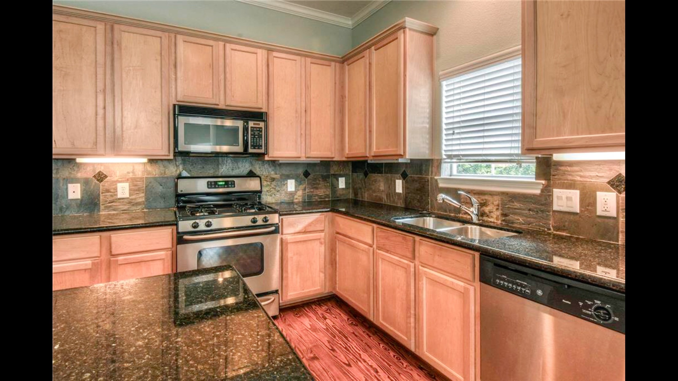 5415 Kansas Street Houston, TX 77007 - Photo 2 of 10 a kitchen with stainless steel appliances granite countertop a stove a sink and a microwave