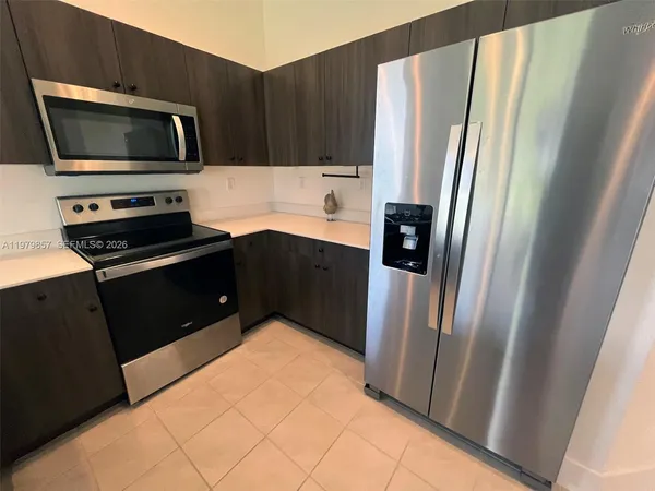 a kitchen with stainless steel appliances a refrigerator and a stove top oven