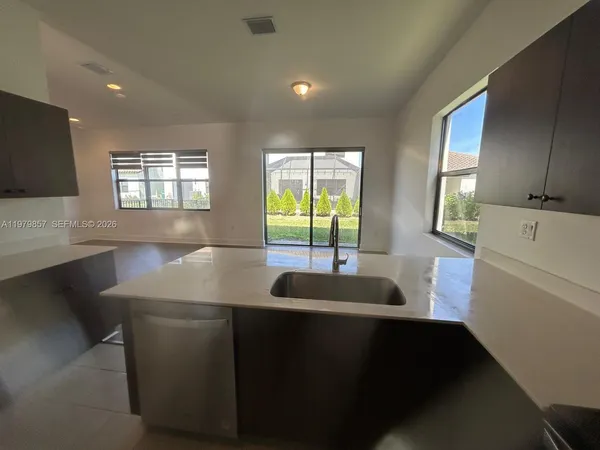 a kitchen with a sink a window and cabinets