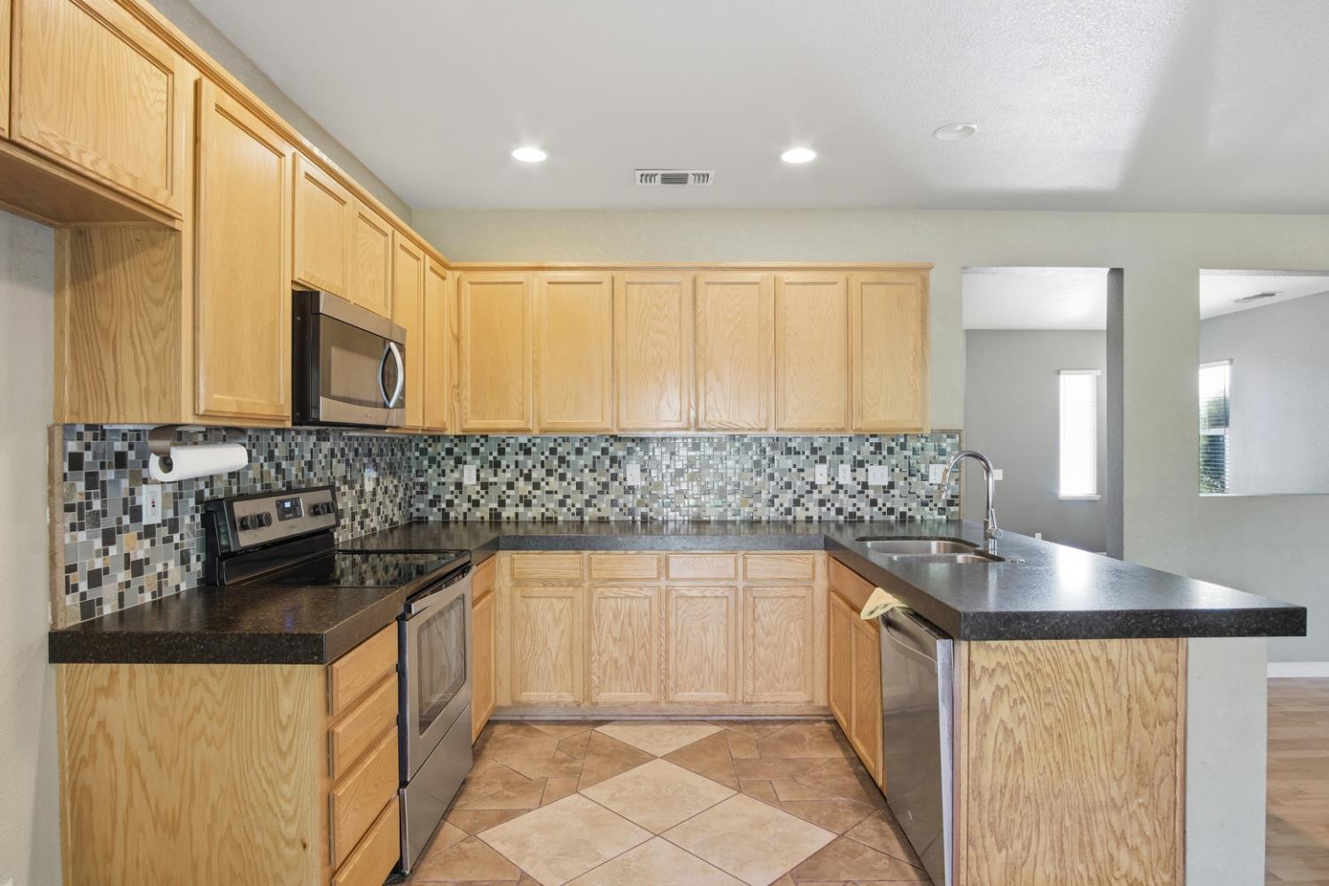 2213 Lionudakis Court Modesto, CA 95355 - Photo 17 of 38 a kitchen with stainless steel appliances granite countertop a sink and a stove