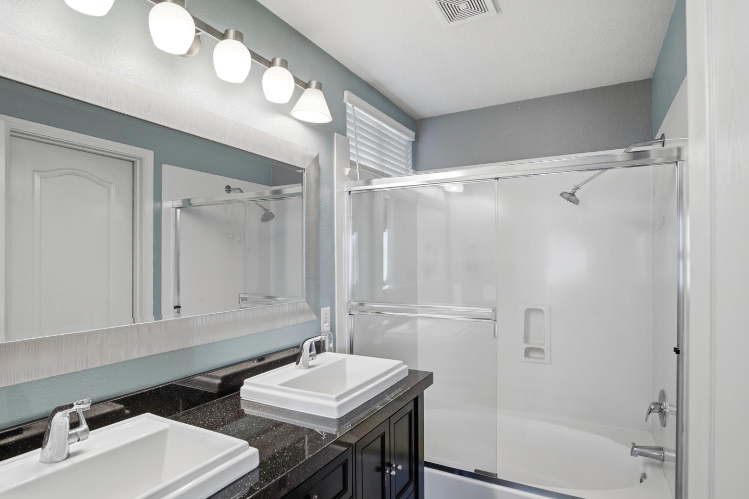 2213 Lionudakis Court Modesto, CA 95355 - Photo 26 of 38 a bathroom with a double vanity sink mirror and shower