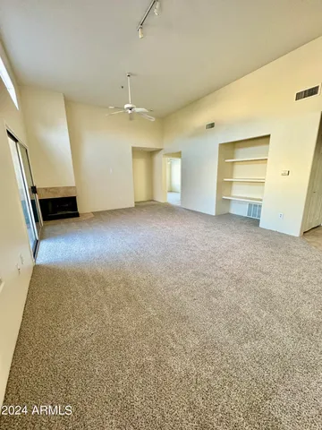 an empty room with a ceiling fan and window