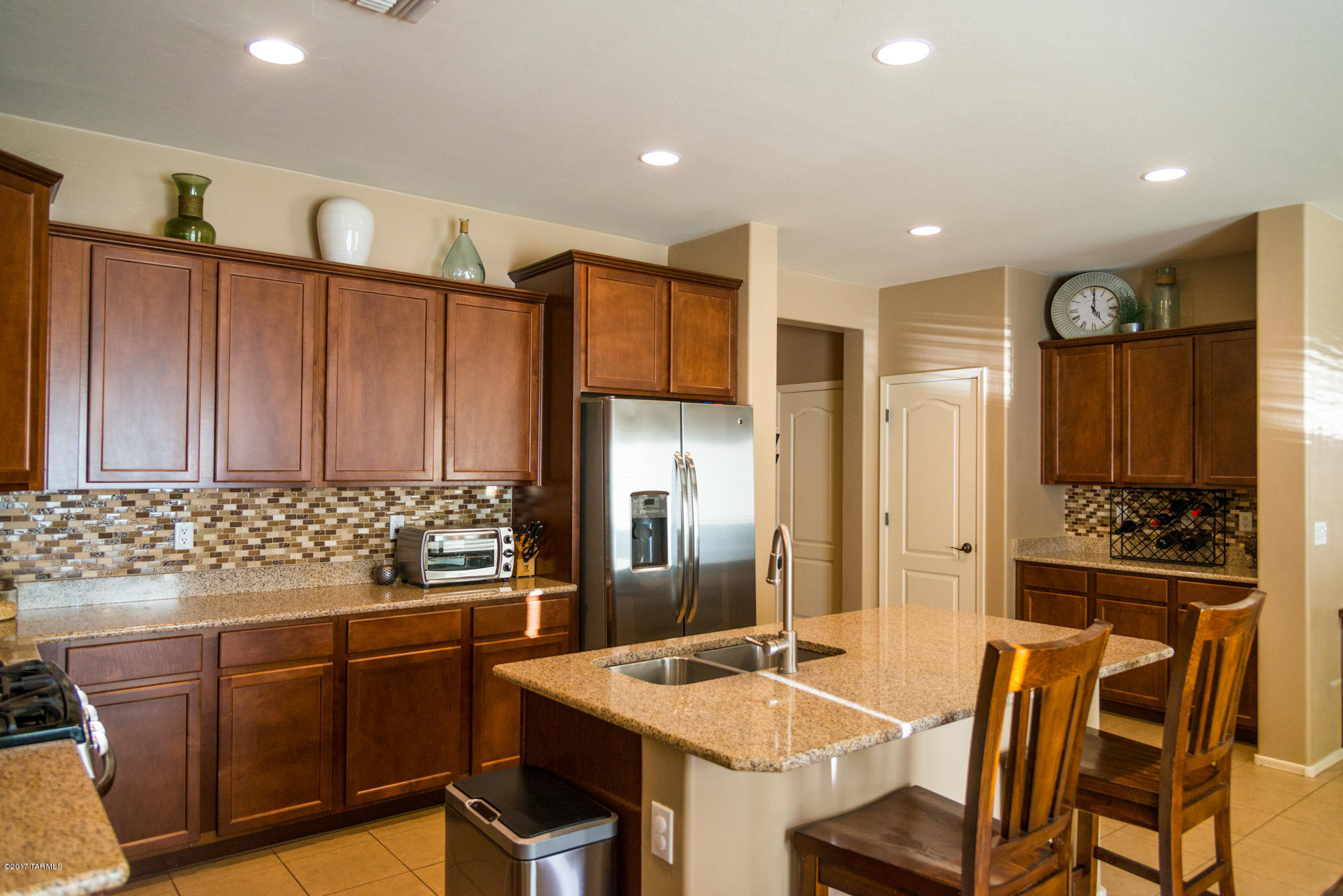 4405 West Crystal Ranch Place Marana, AZ 85658 - Photo 9 of 44 a kitchen with stainless steel appliances kitchen island granite countertop a refrigerator and a stove
