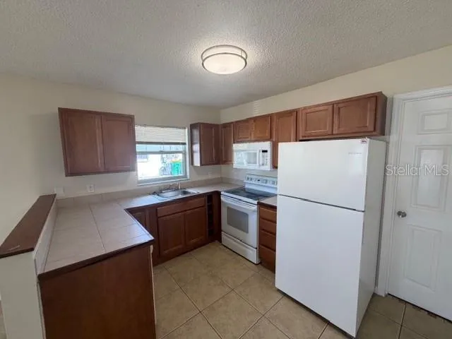 a kitchen with granite countertop a refrigerator and a sink