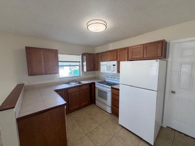11089 Pendleton Avenue, Unit B Englewood, FL 34224 - Photo 11 of 19 a kitchen with granite countertop a refrigerator and a sink