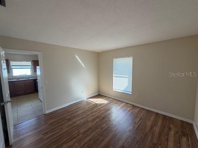 11089 Pendleton Avenue, Unit B Englewood, FL 34224 - Photo 14 of 19 an empty room with wooden floor and windows