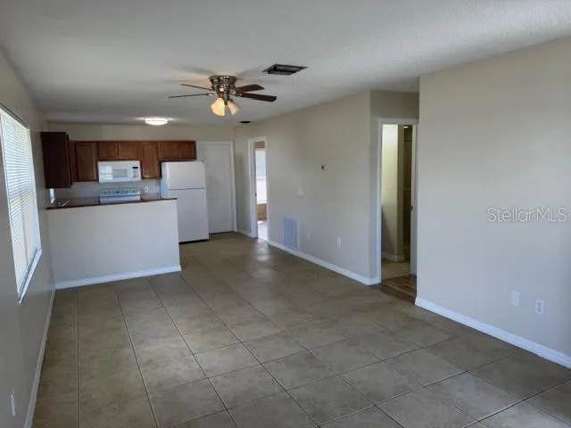 a view of a kitchen with a sink and dishwasher cabinet a fireplace with wooden floor