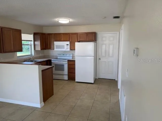 a kitchen with a refrigerator sink and stove