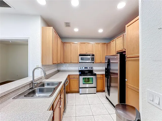 an empty room with wooden floor and ceiling fan