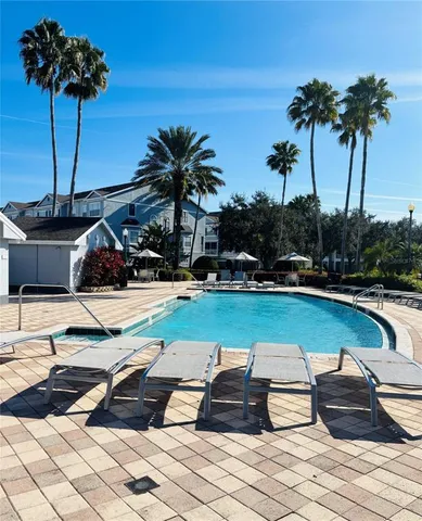 a view of a house with pool and chairs