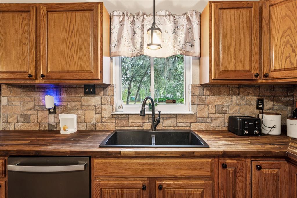 11185 Cleever Street Weeki Wachee, FL 34614 - Photo 15 of 61 a kitchen with stainless steel appliances granite countertop a sink a stove and a microwave