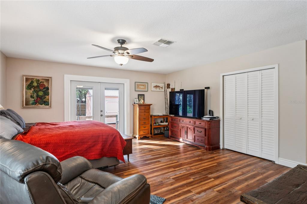 11185 Cleever Street Weeki Wachee, FL 34614 - Photo 23 of 61 a bedroom with a bed and wooden floor