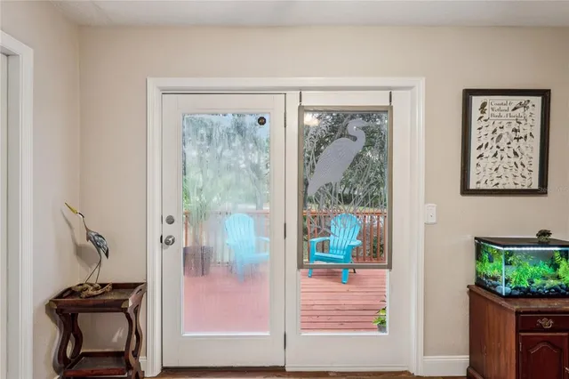 a kitchen with stainless steel appliances granite countertop a stove a refrigerator a kitchen island a dining table and chairs with wooden floor