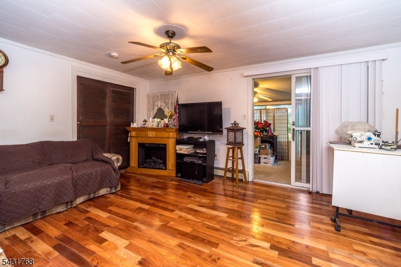 400 Mechlin Corner Road Pittstown, NJ 08867 - Photo 5 of 29 a living room with furniture a fireplace and a flat screen tv