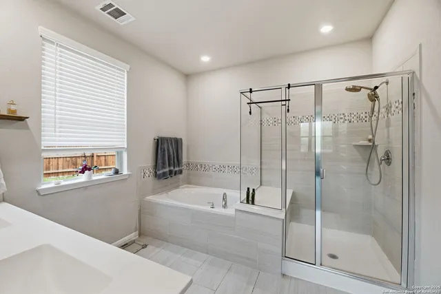 a bathroom with a tub sink and mirror