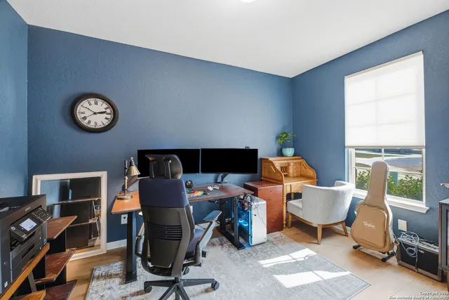 a view of a workspace with furniture and a window