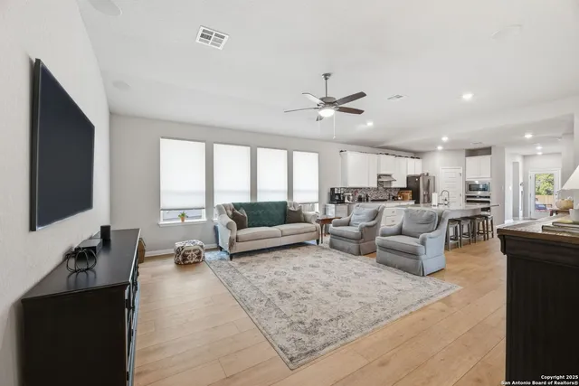 a living room with furniture a flat screen tv and a window
