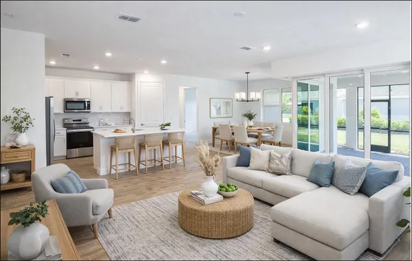 a living room with furniture kitchen and a large window