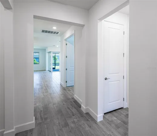 a view of a hallway with wooden floor
