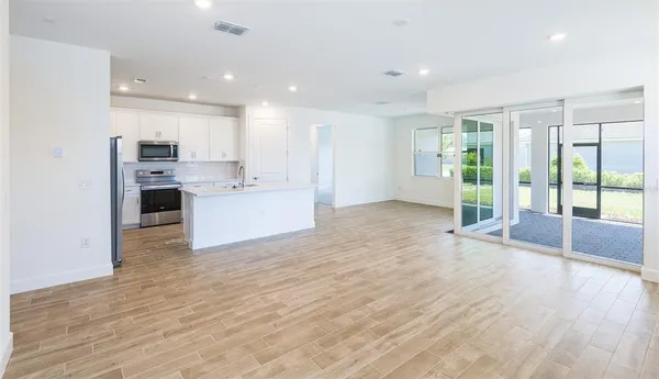 a view of kitchen with wooden floor and electronic appliances