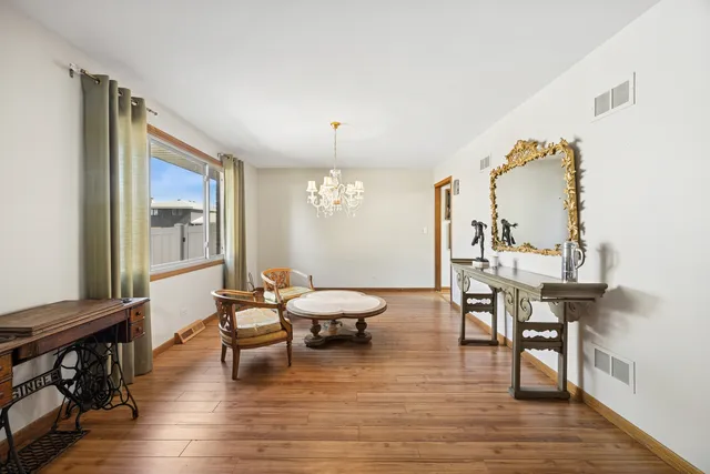 a bedroom with a bed paintings on the wall and a window