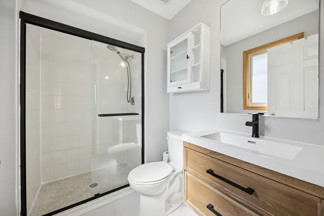 a spacious bedroom with a bed a dresser and a window