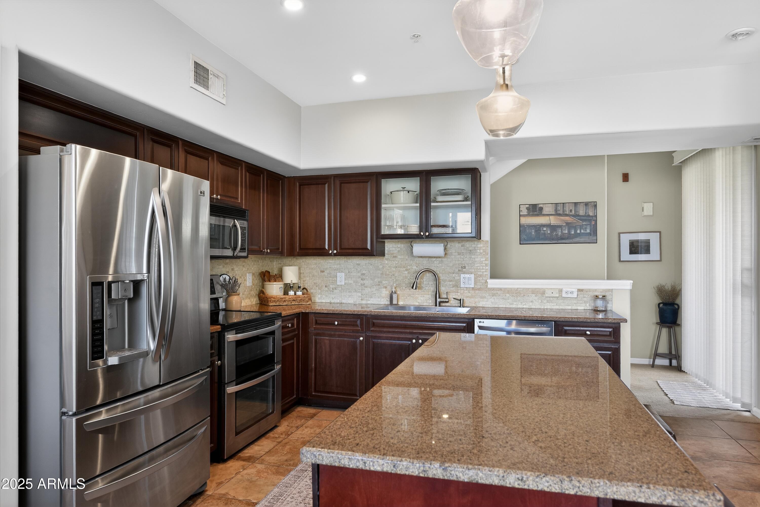 1920 East Bell Road, Unit 1079 Phoenix, AZ 85022 - Photo 13 of 29 a kitchen with stainless steel appliances granite countertop a sink stove and refrigerator