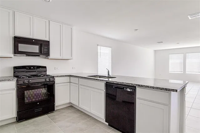 a kitchen with stainless steel appliances granite countertop a stove and a microwave