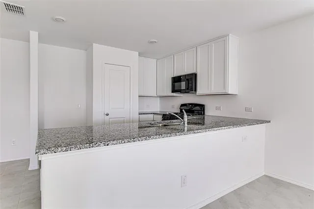 a kitchen with stainless steel appliances granite countertop a sink a stove a microwave a sink and cabinets