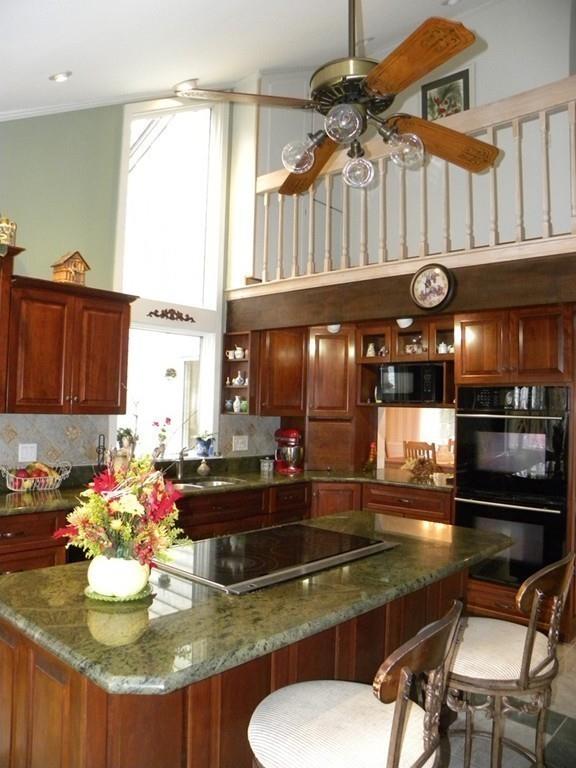 101 Vinton Road Holland, MA 01521 - Photo 26 of 42 a kitchen with a stove a refrigerator and a dining table with wooden floor