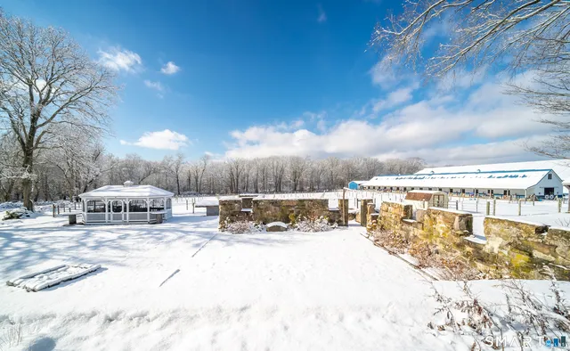 a view of a house with a yard covered in snow
