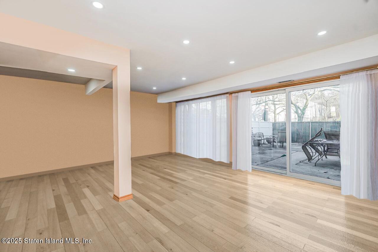 111 Hampton Green Staten Island, NY 10312 - Photo 11 of 19 a view of an empty room with wooden floor and a window