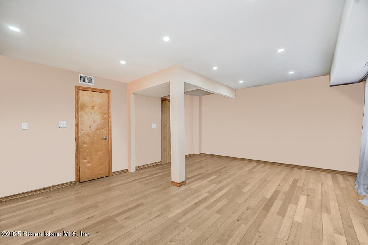 111 Hampton Green Staten Island, NY 10312 - Photo 12 of 19 a view of an empty room with wooden floor and entryway