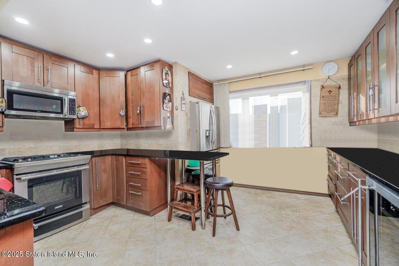 111 Hampton Green Staten Island, NY 10312 - Photo 2 of 19 a kitchen with table chairs sink and cabinets
