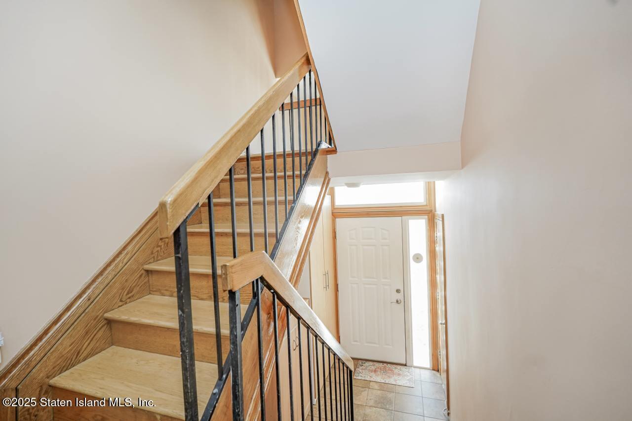 111 Hampton Green Staten Island, NY 10312 - Photo 5 of 19 a view of staircase with wooden floor and white walls