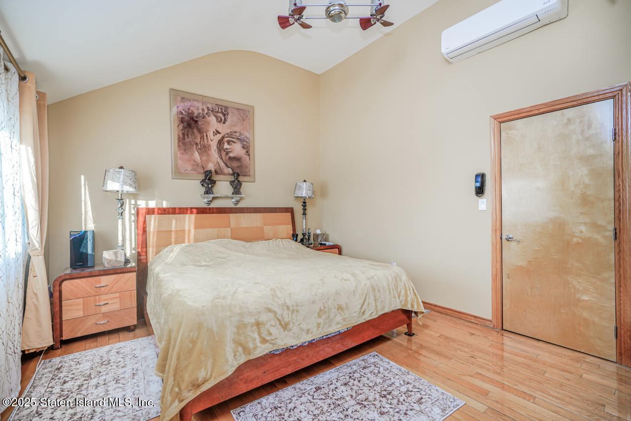 111 Hampton Green Staten Island, NY 10312 - Photo 8 of 19 a bedroom with a bed and a painting on the wall