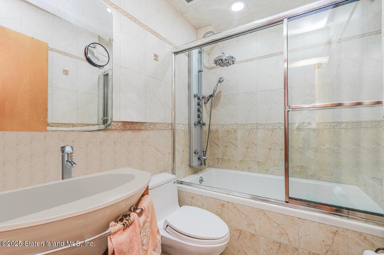 111 Hampton Green Staten Island, NY 10312 - Photo 10 of 19 a bathroom with a toilet a sink and a bathtub