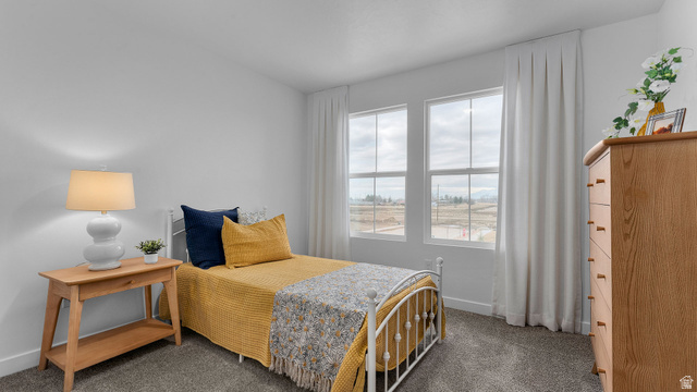 2032 East Dorset Way, Unit 286 Salem, UT 84653 - Photo 12 of 23 Carpeted room featuring two large windows with white trim, a light-colored wood dresser, and a white metal bed frame