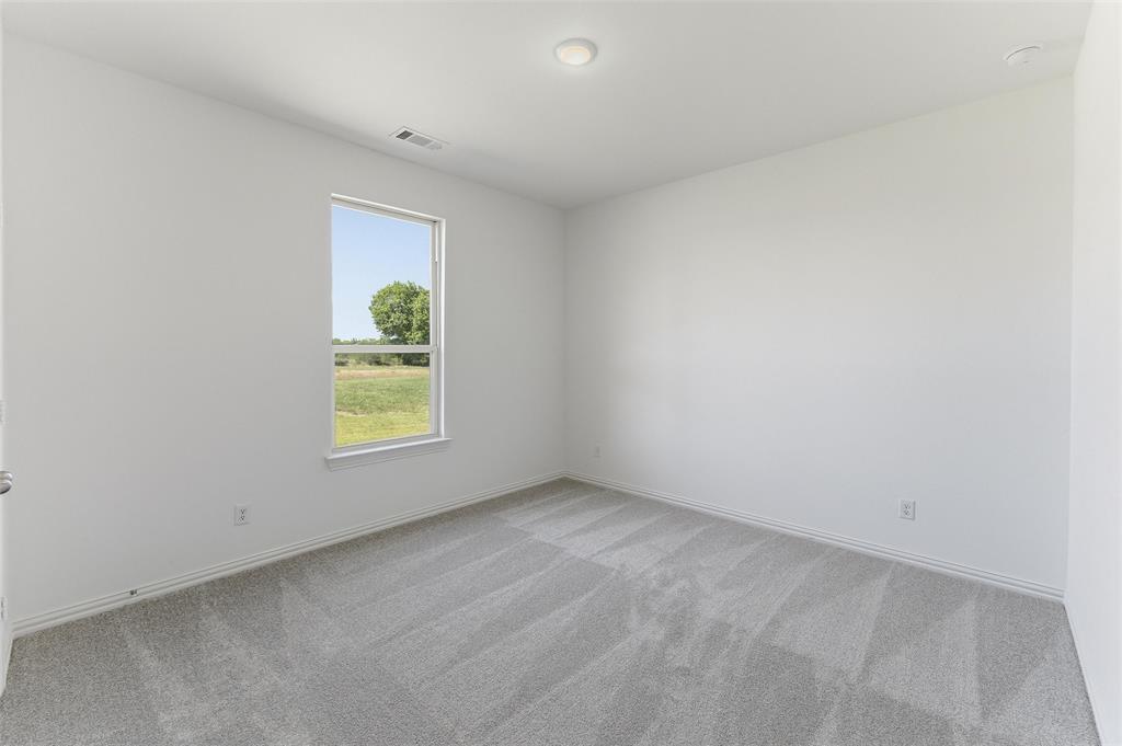 130 Fossil Canyon Drive Rhome, TX 76078 - Photo 15 of 25 Neutral-toned room featuring a single window, recessed ceiling lighting, and light gray patterned carpeting