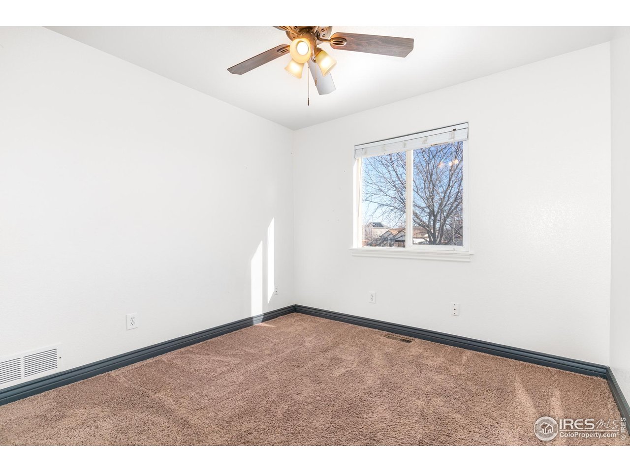 3418 Windmill Court Evans, CO 80620 - Photo 11 of 31 an empty room with a window and a ceiling fan