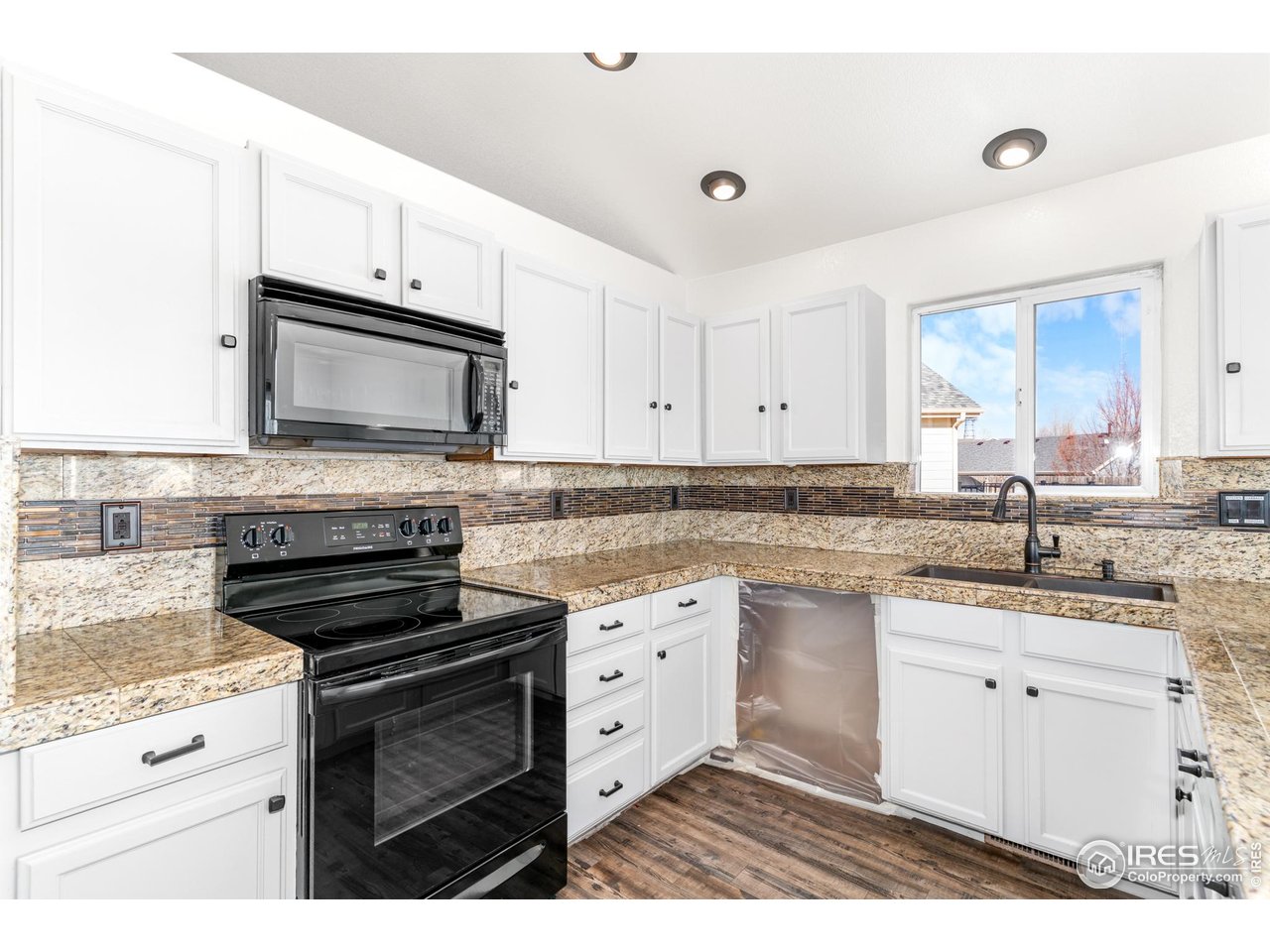 3418 Windmill Court Evans, CO 80620 - Photo 6 of 31 a kitchen with granite countertop white cabinets white stainless steel appliances and sink