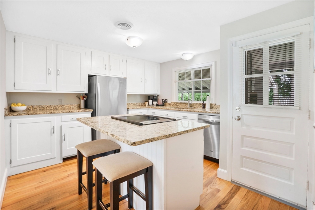 38 Fallston Street Springfield, MA 01119 - Photo 10 of 35 a kitchen with a refrigerator a stove a sink and white cabinets with wooden floor